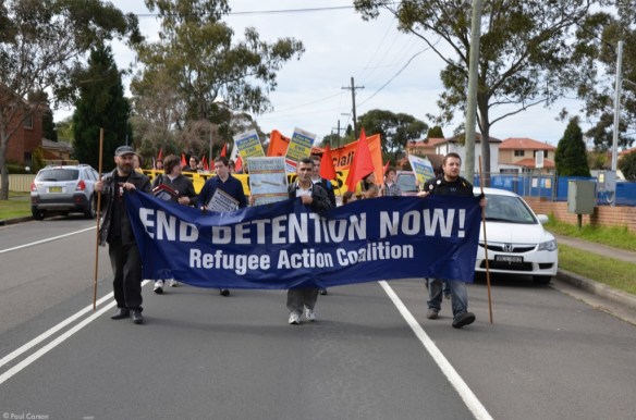 Protesters carry a banner through the screets surrounding the Villawood Immigration Detention Centre.